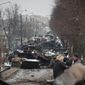 People look at the gutted remains of Russian military vehicles on a road in the town of Bucha, close to the capital Kyiv, Ukraine, Tuesday, March 1, 2022. Russia on Tuesday stepped up shelling of Kharkiv, Ukraine&#x27;s second-largest city, pounding civilian targets there. Casualties mounted and reports emerged that more than 70 Ukrainian soldiers were killed after Russian artillery recently hit a military base in Okhtyrka, a city between Kharkiv and Kyiv, the capital. (AP Photo/Serhii Nuzhnenko)
