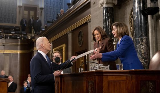 President Joe Biden presents copies of his speech to Vice President Kamala Harris and Speaker of the House Nancy Pelosi of Calif., as he arrives to deliver his State of the Union address to a joint session of Congress at the Capitol, Tuesday, March 1, 2022, in Washington. (Saul Loeb, Pool via AP)