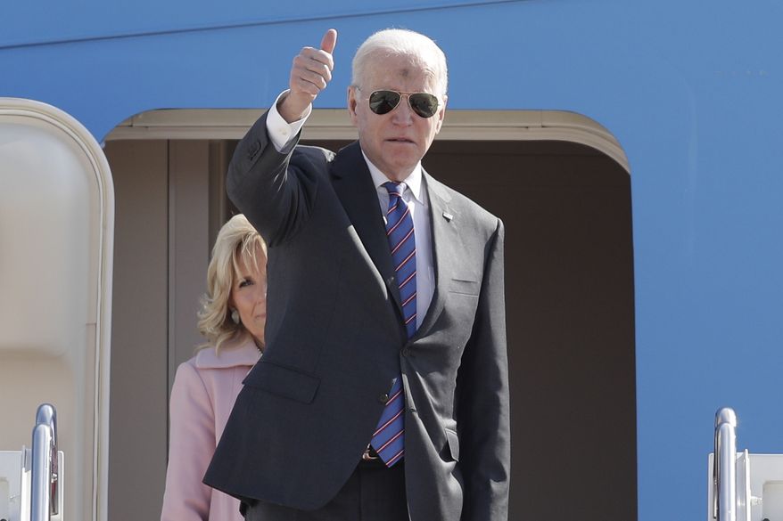 President Joe Biden gestures from the stairs of Air Force One as first lady Jill Biden looks on at Andrews Air Force Base, Md., Wednesday, March 2, 2022. Biden is en route to Superior, Wisc., to promote his infrastructure agenda. (AP Photo/Luis M. Alvarez)