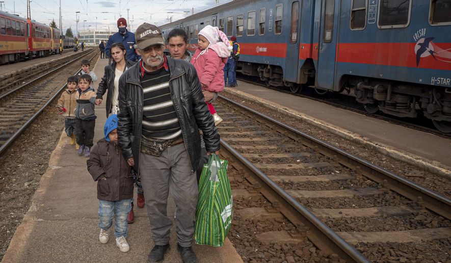 Refugees fleeing the war from neighboring Ukraine walk on a platform after disembarking from a train in Zahony, Hungary, Wednesday, March 2, 2022. At the train station in the Hungarian town of Zahony on Wednesday, more than 200 Ukrainians with disabilities — residents of two care homes in Ukraine&#39;s capital of Kyiv — disembarked into the cold wind of the train platform after an arduous escape from the violence gripping Ukraine. (AP Photo/Balazs Kaufmann)
