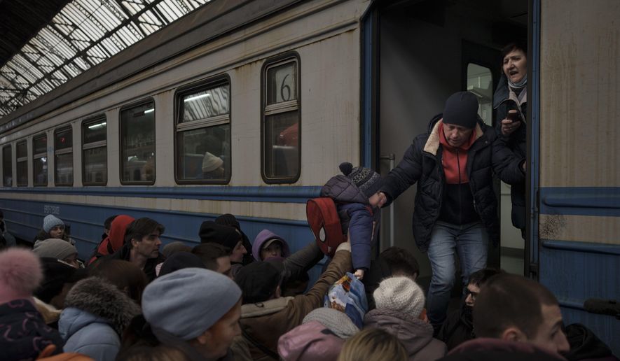 Passengers rush to board a train leaving to Slovakia from the Lviv railway station, in Lviv, west Ukraine, Wednesday, March 2, 2022. Russian forces have escalated their attacks on crowded cities in what Ukraine&#x27;s leader called a blatant campaign of terror. (AP Photo/Felipe Dana)