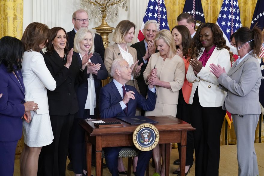 President Joe Biden hands a pen to Gretchen Carlson after signing a bill to end forced arbitration in sexual harassment cases in the workplace, Thursday, March 3, 2022, in the East Room of the White House in Washington. (AP Photo/Patrick Semansky)