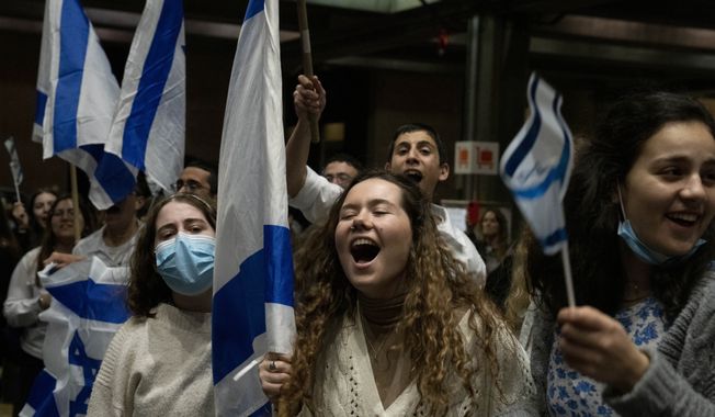 Israeli youth sing and cheer for people arriving from Ukraine at Ben Gurion Airport, Thursday, March 3, 2022. (AP Photo/Maya Alleruzzo)