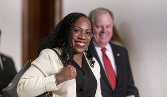 Supreme Court nominee Ketanji Brown Jackson smiles as she arrives for a meeting with Sen. Ben Sasse, R-Neb., a member of the Judiciary Committee, at the Capitol in Washington, Thursday, March 3, 2022. She is escorted by former Sen. Doug Jones, right, who was asked by the White House to help guide Jackson through the process. (AP Photo/J. Scott Applewhite) ** FILE **