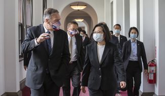 In this photo released by the Taiwan Presidential Office, former U.S. Secretary of State Mike Pompeo, left, and Taiwan&#39;s President Tsai Ing-wen, right, walk together during a meeting at the Presidential Office in Taipei, Taiwan, Thursday, March 3, 2022. (Taiwan Presidential Office via AP)