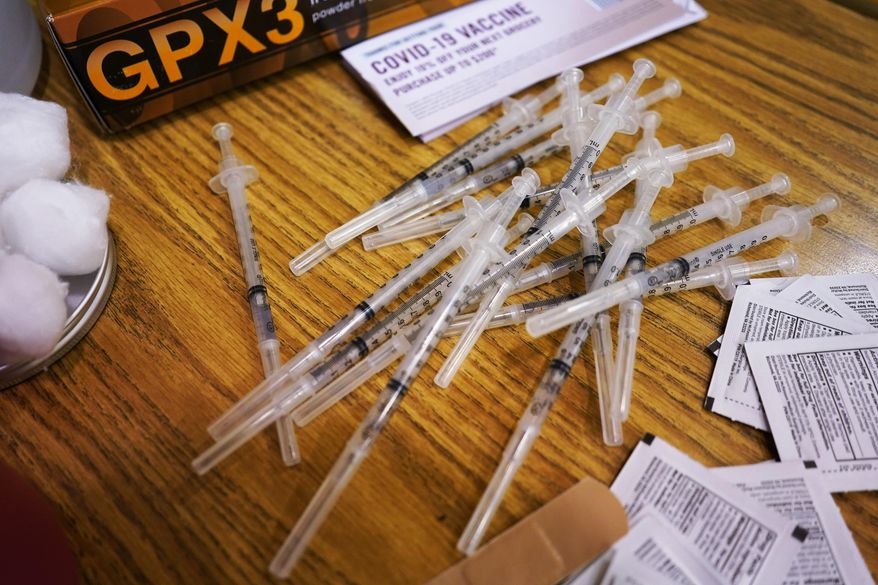 Prepared Pfizer COVID-19 vaccine syringes wait for patients at a middle school in Wheeling, Ill., Friday, June 11, 2021. As demand for COVID-19 vaccines collapses in many areas of the U.S., states are scrambling to use stockpiles of doses before they expire and have to be added to the millions that have already gone to waste. (AP Photo/Nam Y. Huh, File)