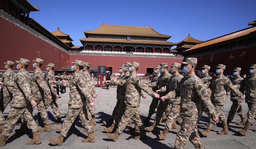 Chinese military personnel walk in formation outside the entrance to the Forbidden City in Beijing, Saturday, March 5, 2022. China is raising its defense spending in 2022 by 7.1% to $229 billion, up from a 6.8% increase the year before. (AP Photo/Ng Han Guan)