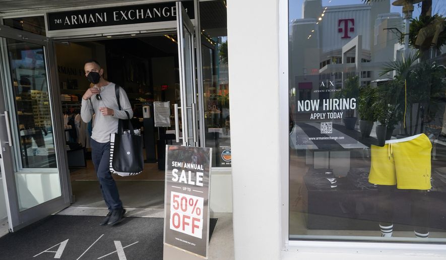 For sale and hiring signs are displayed at an Armani Exchange store, Friday, Jan. 21, 2022, in Miami Beach, Fla. (AP Photo/Marta Lavandier)