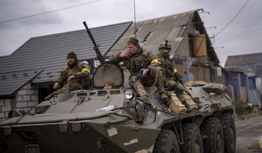 Ukrainian soldiers drive on an armored military vehicle in the outskirts of Kyiv, Ukraine, Saturday, March 5, 2022. (AP Photo/Emilio Morenatti)