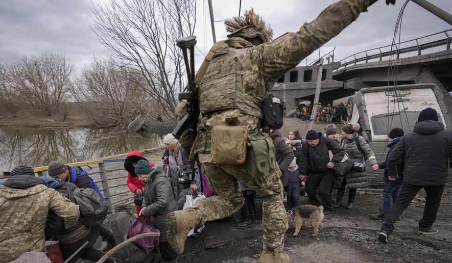 People cross the Irpin river on an improvised path under a bridge that was destroyed by a Russian airstrike, while fleeing the town of Irpin, Ukraine, Saturday, March 5, 2022. What looked like a breakthrough cease-fire to evacuate residents from two cities in Ukraine quickly fell apart Saturday as Ukrainian officials said shelling had halted the work to remove civilians hours after Russia announced the deal. (AP Photo/Vadim Ghirda)