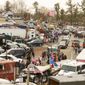 Cars, trucks and people arrive at Hagerstown Speedway as the People Convoy of Truckers stages Saturday, March 5, 2022, in Hagerstown, Md. The convoy of trucks is planning to head into the Washington area.(AP Photo/Jon Elswick)