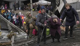 An elderly lady is assisted while crossing the Irpin river, under a bridge that was destroyed by a Russian airstrike, as civilians flee the town of Irpin, Ukraine, Saturday, March 5, 2022. What looked like a breakthrough cease-fire to evacuate residents from two cities in Ukraine quickly fell apart Saturday as Ukrainian officials said shelling had halted the work to remove civilians hours after Russia announced the deal. (AP Photo/Vadim Ghirda)