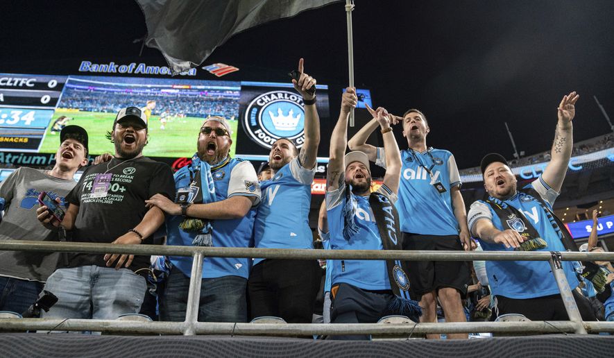 Fans cheer before an MLS soccer match between the Charlotte FC and the LA Galaxy in Charlotte, N.C., Saturday, March 5, 2022. (AP Photo/Jacob Kupferman)