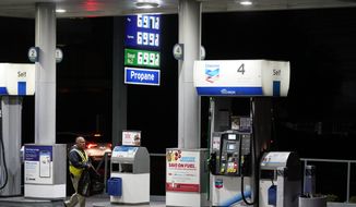 An attendant walks past a pump at a station selling gas at more than $6 a gallon, Monday, March 7, 2022, in Los Angeles. (AP Photo/Marcio Jose Sanchez)