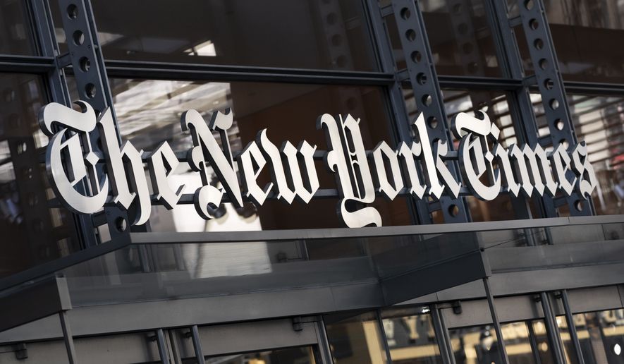 A sign for The New York Times hangs above the entrance to its building in New York on May 6, 2021. (AP Photo/Mark Lennihan, File)