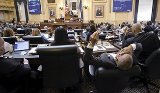 Del. Luke Torian, D-Prince William, right, one of the budget conferees from the House, shows the strain of long hours as he leans back during the floor session of the House of Delegates inside the State Capitol in Richmond, Va., on Monday, March 7, 2022. (Bob Brown/Richmond Times-Dispatch via AP)