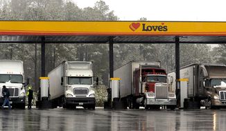 In this Feb. 11, 2014, file photo, truck drivers stop at a gas station in Emerson, Ga., north of metro Atlanta, to fill up their tractor trailer rigs. (AP Photo/David Tulis, File)