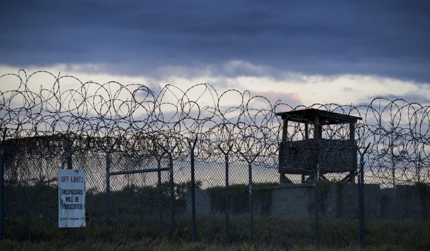 In this photo reviewed by U.S. military officials, the sun sets behind the closed Camp X-Ray detention facility, on April 17, 2019, in Guantanamo Bay Naval Base, Cuba. A Saudi prisoner at the Guantanamo Bay detention center who was suspected of trying to join the 9/11 hijackers has been sent back to his home country for treatment for mental illness. The Department of Defense says Mohammad Ahmad al-Qahtani was flown back to Saudi Arabia from the U.S. base in Cuba after a review board concluded he could be safely released after 20 years in custody. (AP Photo/Alex Brandon, File)