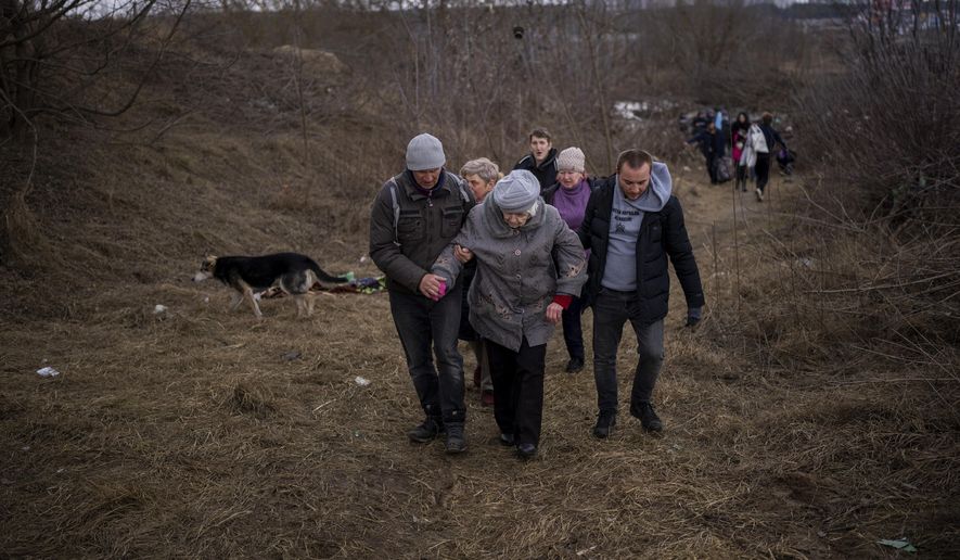 People flee Irpin on the outskirts of Kyiv, Ukraine, Monday, March 7, 2022, as the artillery echoes nearby. Russia announced yet another cease-fire and a handful of humanitarian corridors to allow civilians to flee Ukraine. Previous such measures have fallen apart and Moscow&#39;s armed forces continued to pummel some Ukrainian cities with rockets Monday. (AP Photo/Emilio Morenatti)