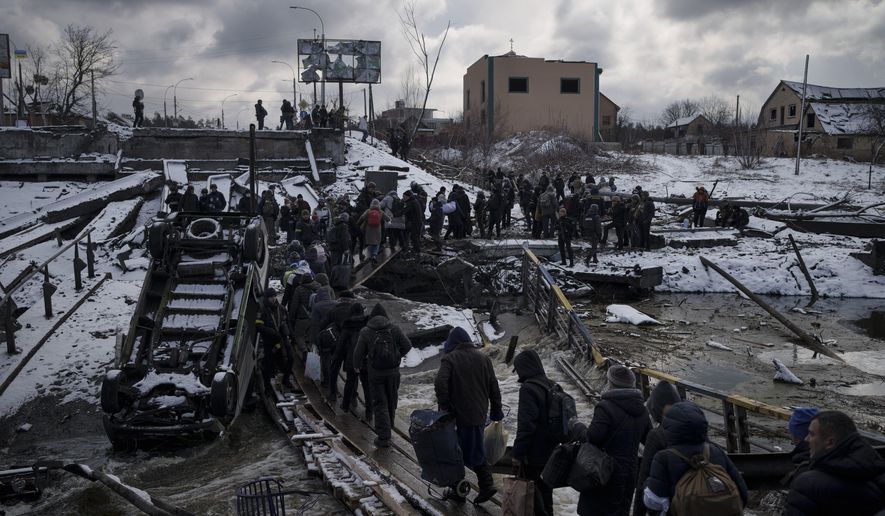 Ukrainians cross an improvised path under a destroyed bridge while fleeing Irpin, in the outskirts of Kyiv, Ukraine, Tuesday, March 8, 2022. Demands for ways to safely evacuate civilians have surged along with intensifying shelling by Russian forces, who have made significant advances in southern Ukraine but stalled in some other regions. Efforts to put in place cease-fires along humanitarian corridors have repeatedly failed amid Russian shelling. (AP Photo/Felipe Dana)