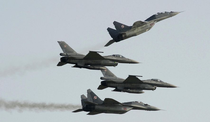 In this file photo, two Polish Air Force Russian-made MiG-29&#x27;s fly above and below two Polish Air Force U.S. made F-16&#x27;s fighter jets during the Air Show in Radom, Poland, on Aug. 27, 2011. The Polish government said on March 8, 2022, that it is prepared to hand over its entire fleet of MiG-29 fighters to the United States for possible use in Ukraine, so long as Washington and its NATO allies provide Warsaw with comparable combat aircraft. (AP Photo/Alik Keplicz, File) ** FILE **