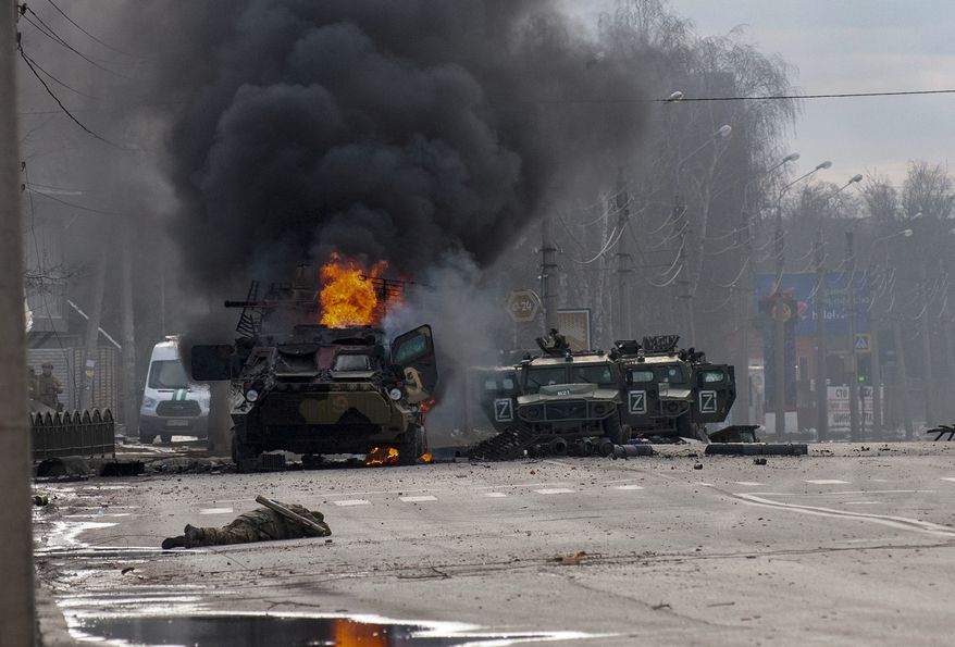 A Russian armored personnel carrier burns amid damaged and abandoned light utility vehicles after fighting in Kharkiv, Ukraine, Feb. 27, 2022. (AP Photo/Marienko Andrew, File)