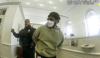 A police officer detains &amp;quot;Black Panther&amp;quot; director Ryan Coogler at a Bank of America branch in Atlanta, in this January 2022 image made from Atlanta Police video. Coogler was mistaken for a bank robber at the bank. (Atlanta Police Department via AP)