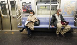 Commuters wear face masks and social distance while riding an M Train, Tuesday, March 9, 2021, in New York&#39;s subway system. The Centers for Disease Control and Prevention is developing guidance that will ease the nationwide mask mandate for public transit next month. That&#39;s according to a U.S. official. (AP Photo/Mary Altaffer) **FILE**