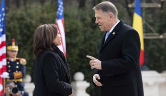 Romanian President Klaus Iohannis, right, speaks with U.S. Vice President Kamala Harris as she arrives at Cotroceni Palace in Otopeni, Romania, Friday, March 11, 2022. (Saul Loeb/Pool Photo via AP)