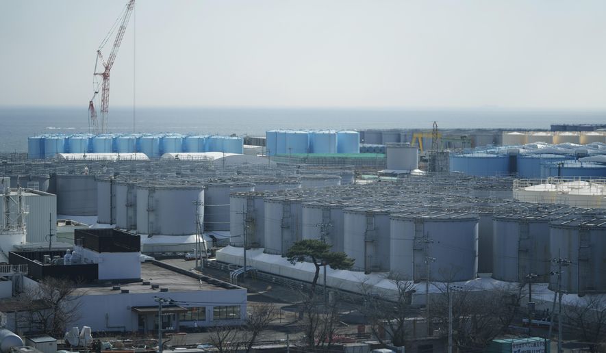 Tanks storing treated radioactive water after it was used to cool the melted fuel are seen at the Fukushima Daiichi nuclear power plant, run by Tokyo Electric Power Company Holdings (TEPCO), in Okuma town, northeastern Japan, Thursday, March 3, 2022. The government has announced plans to release the water after treatment and dilution to well below the legally releasable levels through a planned undersea tunnel at a site about 1 kilometer offshore. (AP Photo/Hiro Komae)
