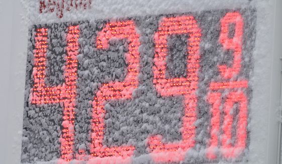 Snow partially obscures the price of gasoline at a gas station, Saturday, March 12, 2022, in Lutherville-Timonium, Md. Much of the northeast is experiencing a late winter storm dropping snow and high winds. (AP Photo/Julio Cortez)