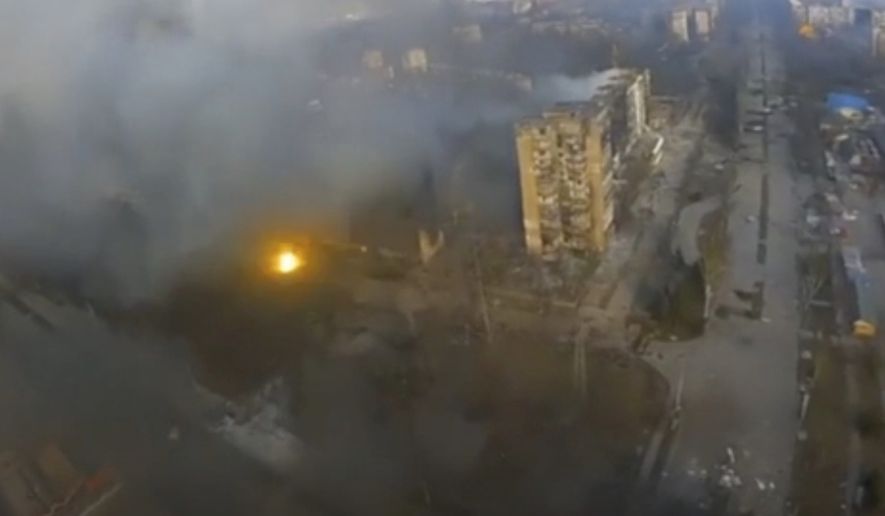This image taken from video provided by Azov Battalion shows an aerial view of dark smoke rising from several buildings and a flash of light from an apparent blast in Mariupol, Ukraine, Monday March 14, 2022. Mariupol, which sits on the Azov Sea, is surrounded by Russian forces and has come under heavy bombardment recently. (Azov Battalion via AP)