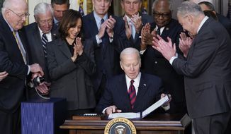 President Joe Biden is applauded after signing the Consolidated Appropriations Act for Fiscal Year 2022 in the Indian Treaty Room in the Eisenhower Executive Office Building on the White House Campus in Washington, Tuesday, March 15, 2022. (AP Photo/Patrick Semansky)