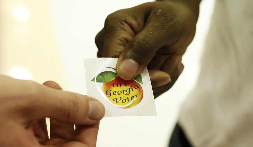 A voters picks up a, &quot;I&#x27;m a Georgia Voter,&quot; sticker after voting at Clarke Central High School in Athens, Ga., on Tuesday, Nov. 3, 2020. House Republicans pushed through a bill to make further changes to Georgia&#x27;s voting rules late Tuesday, March 15, 2022, over Democratic objections that the GOP was feeding an insatiable monster — Donald Trump&#x27;s “big lie” that Georgia&#x27;s 2020 election was stolen from the former president, despite no evidence. (Joshua L. Jones/Athens Banner-Herald via AP) **FILE**