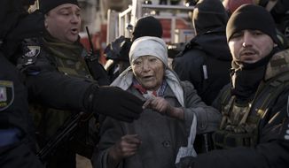 An elderly woman is helped by policemen after she was rescued by firefighters from inside her apartment after bombing in Kyiv, Ukraine, Tuesday, March 15, 2022. Russia’s offensive in Ukraine has edged closer to central Kyiv with a series of strikes hitting a residential neighborhood as the leaders of three European Union member countries planned a visit to Ukraine’s embattled capital. (AP Photo/Felipe Dana)