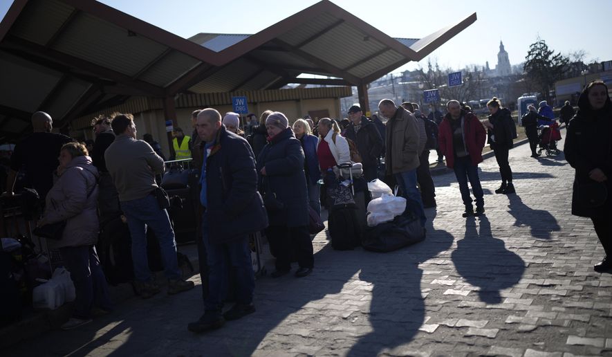 People wait in a line to board a train leaving for Lviv in Ukraine at the train station in Przemysl, Poland, Monday, March 14, 2022. While tens of thousands of people have fled Ukraine every day since Russia&#x27;s invasion, a small but growing number are heading in the other direction. At first they were foreign volunteers, Ukrainian expatriate men heading to fight and people delivering aid. But increasingly, women are also heading back. (AP Photo/Daniel Cole)