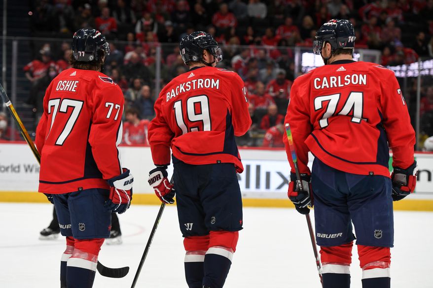 Washington Capitals Right Wing T.J. Oshie (77), Center Nicklas Backstrom (19) and Defenseman John Carlson (74) talk it over during a break in the action during the 1st period against the Carolina Hurricanes at Capital One Arena in Washington D.C., March 3, 2022. (Photo by All-Pro Reels)