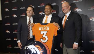 Denver Broncos new starting quarterback Russell Wilson, center, is flanked by head coach Nathaniel Hackett, right, and general manager George Paton after a news conference Wednesday, March 16, 2022, at the team&#39;s headquarters in Englewood, Colo. (AP Photo/David Zalubowski)