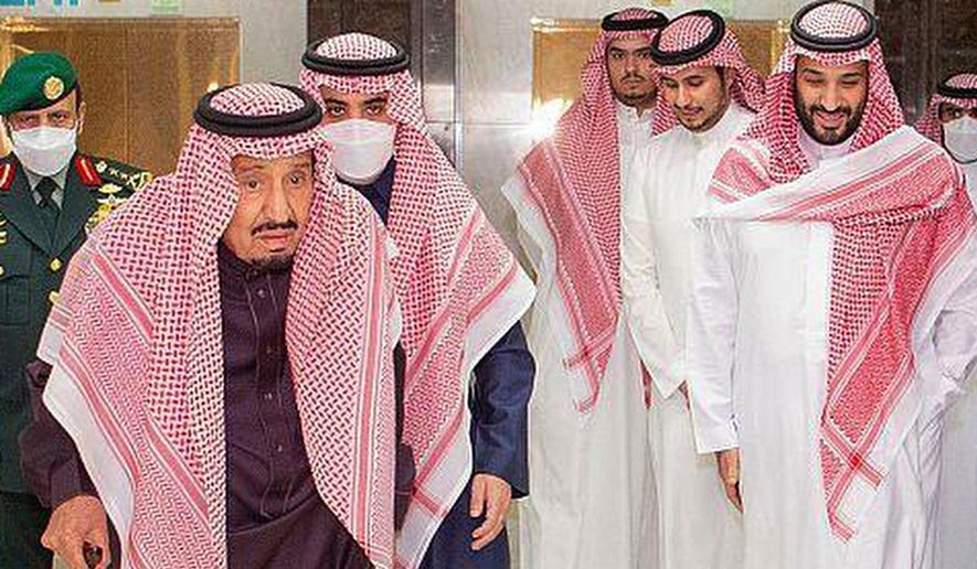 In this photo released by Saudi Press Agency, Saudi King Faisal walks with a cane as he leaves King Faisal Specialist Hospital with Saudi Crown Prince Mohammed bin Salman, right, and entourage, in Riyadh, Saudi Arabia, Wednesday, March, 16, 2022. Saudi Arabia’s octogenarian monarch underwent medical tests and changed the battery of his pacemaker, the state-run Saudi Press Agency reported Wednesday. (Saudi Press Agency via AP)
