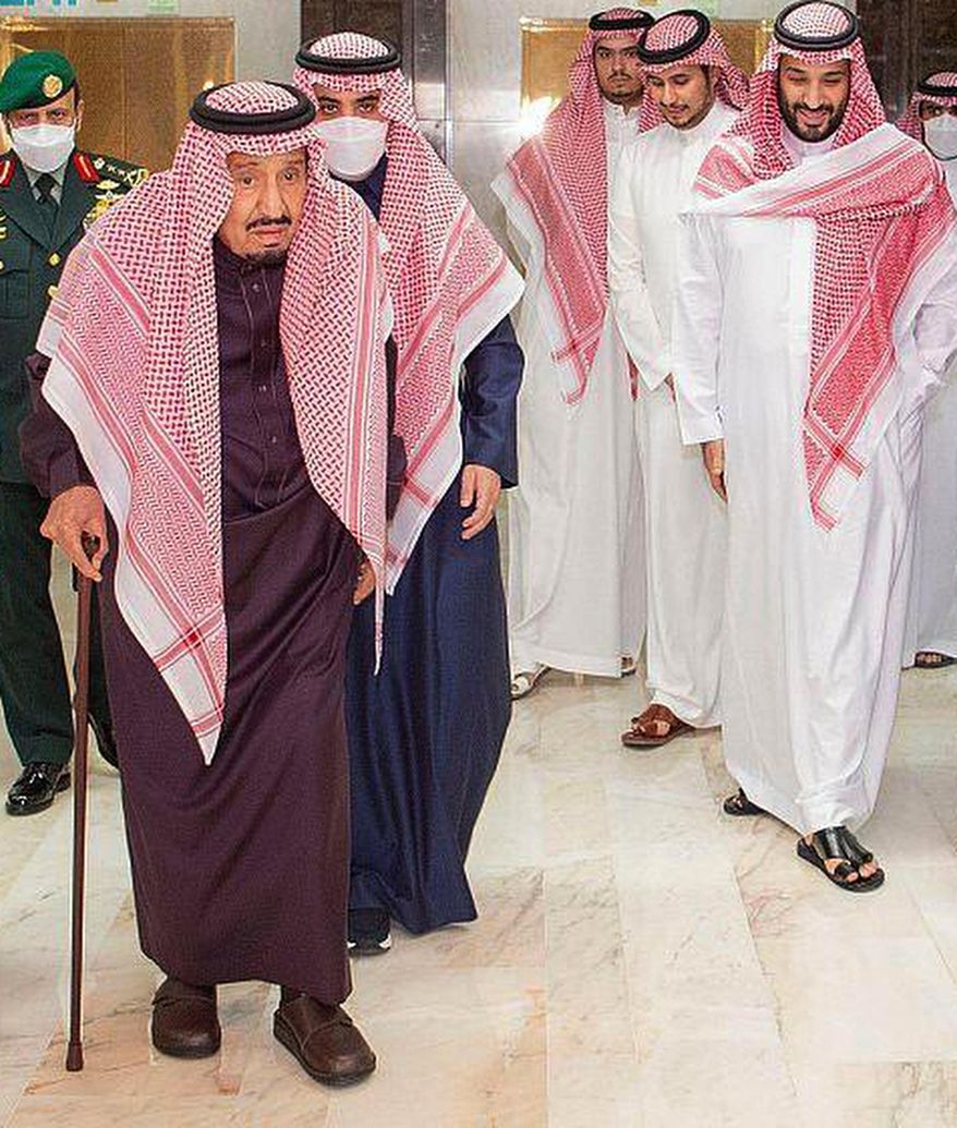 In this photo released by Saudi Press Agency, Saudi King Faisal walks with a cane as he leaves King Faisal Specialist Hospital with Saudi Crown Prince Mohammed bin Salman, right, and entourage, in Riyadh, Saudi Arabia, Wednesday, March, 16, 2022. Saudi Arabia’s octogenarian monarch underwent medical tests and changed the battery of his pacemaker, the state-run Saudi Press Agency reported Wednesday. (Saudi Press Agency via AP)
