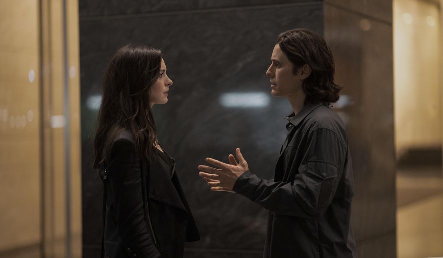 This image released by Apple TV+ shows Anne Hathaway, left, and Jared Leto in a scene from the limited series &amp;quot;WeCrashed,&amp;quot; about the rise and fall of WeWork. (Peter Kramer/Apple TV+ via AP)