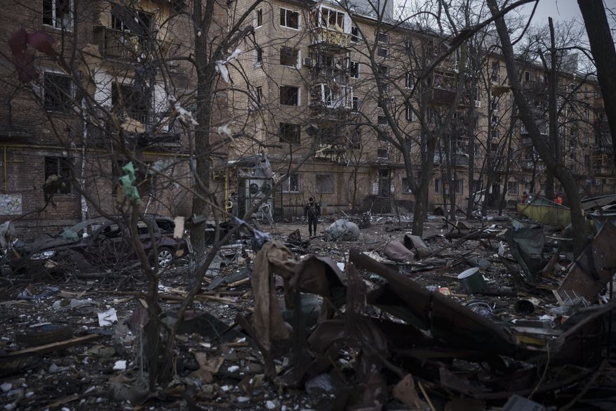 A police officer walks at the site of a bombing that damaged residential buildings in Kyiv, Ukraine, Friday, March 18, 2022. Russian forces pressed their assault on Ukrainian cities Friday, with new missile strikes and shelling on the edges of the capital Kyiv and the western city of Lviv, as world leaders pushed for an investigation of the Kremlins repeated attacks on civilian targets, including schools, hospitals and residential areas. (AP Photo/Felipe Dana)