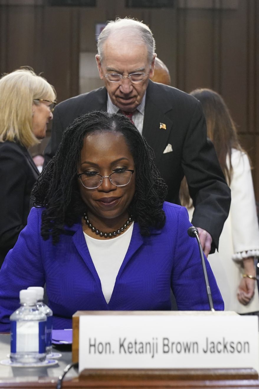 Supreme Court nominee Judge Ketanji Brown Jackson is helped into her seat by Sen. Chuck Grassley, R-Iowa, the ranking member of the Senate Judiciary Committee, as she arrives for her confirmation hearing before the Senate Judiciary Committee Monday, March 21, 2022, on Capitol Hill in Washington. (AP Photo/Jacquelyn Martin)