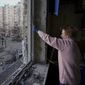 A woman measures a window before covering it with plastic sheets in a building damaged by a bombing the previous day in Kyiv, Ukraine, Monday, March 21, 2022. As Russia intensified its effort to pound Mariupol into submission, its ground offensive in other parts of Ukraine has become bogged down. Western officials and analysts say the conflict is turning into a grinding war of attrition, with Russia bombarding cities.(AP Photo/Vadim Ghirda) **FILE**