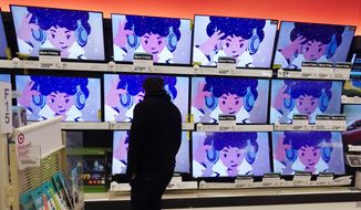 A shopper looks at televisions in a store in Indianapolis on Friday, Nov. 26, 2021. (AP Photo/Darron Cummings, File)