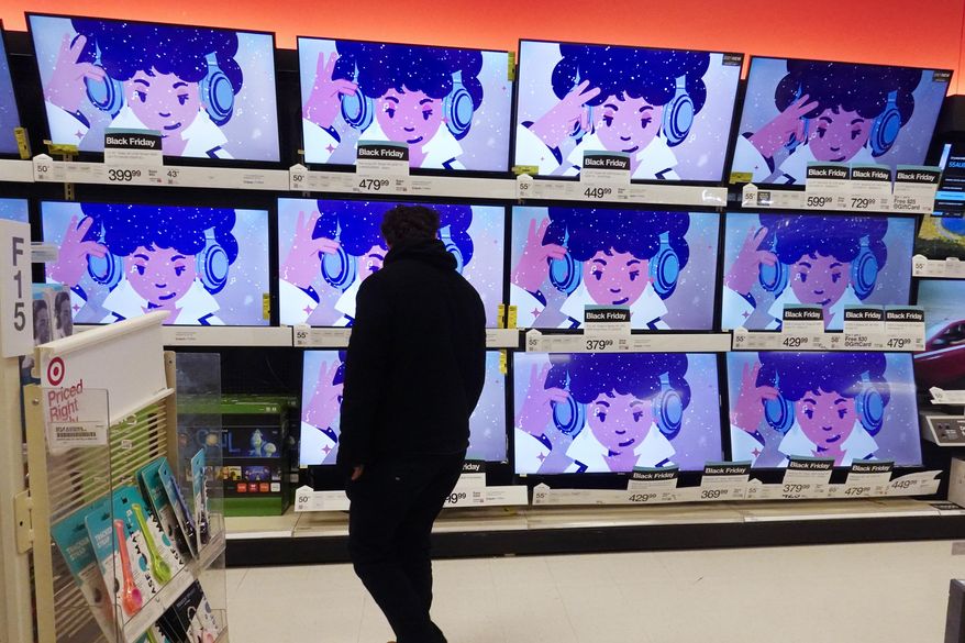 A shopper looks at televisions in a store in Indianapolis on Friday, Nov. 26, 2021. (AP Photo/Darron Cummings, File)
