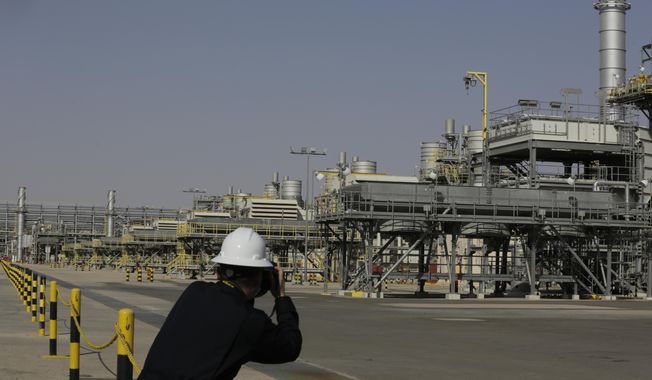 A photographer takes pictures of the Khurais oil field during a tour for journalists, 150 km east-northeast of Riyadh, Saudi Arabia, June 28, 2021. In a statement on Monday, March 21, 2022, carried by the state-run Saudi Press Agency, Saudi Arabia said it “won’t bear any responsibility for any shortage in oil supplies to global markets” after attacks by Yemen’s Iran-backed Houthi rebels have affected the kingdom’s production. (AP Photo/Amr Nabil, File)