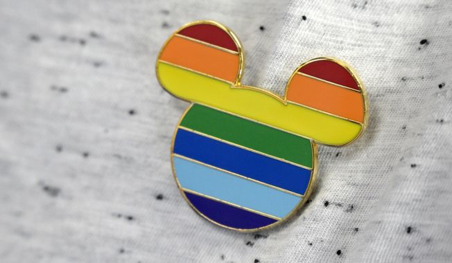 A Disney cast member displays a Mickey Mouse pin on his shirt at The Center, an LGBTQ support organization, while participating in an employee walkout of Walt Disney World, Tuesday, March 22, 2022, in Orlando, Fla. (AP Photo/Phelan M. Ebenhack) ** FILE **