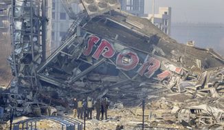 People examine the damage after shelling of a shopping center, in Kyiv, Ukraine, Monday, March 21, 2022. Eight people were killed in the attack. (AP Photo/ (AP Photo/Efrem Lukatsky)