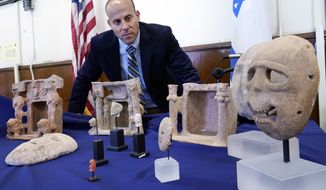 Dr. Etan Klein, Deputy Director of the Theft Prevention Unit, of Israel&#39;s Antiquities Authority, looks over looted antiquities worth $5-million, seized from billionaire hedge fund manager Michael Steinhardt, displayed in the offices of the Manhattan District Attorney, in New York, Tuesday, March 22, 2022. The 39 items being returned to Israel include two gold masks dating from about 5000 B.C. that are valued at $500,000, and a set of three death masks that date from 6000 to 7000 B.C. and are worth a total of $650,000, (AP Photo/Richard Drew)
